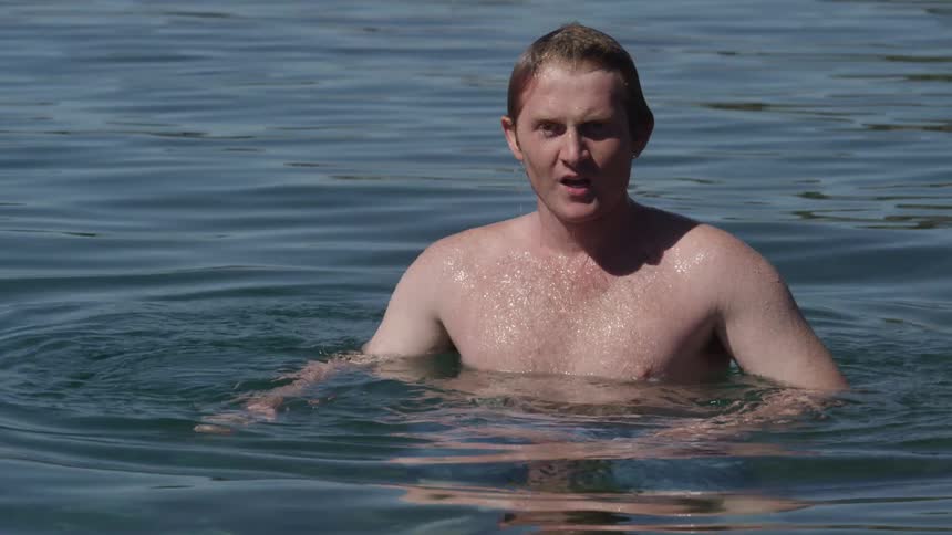 A man pops up coming from under the water