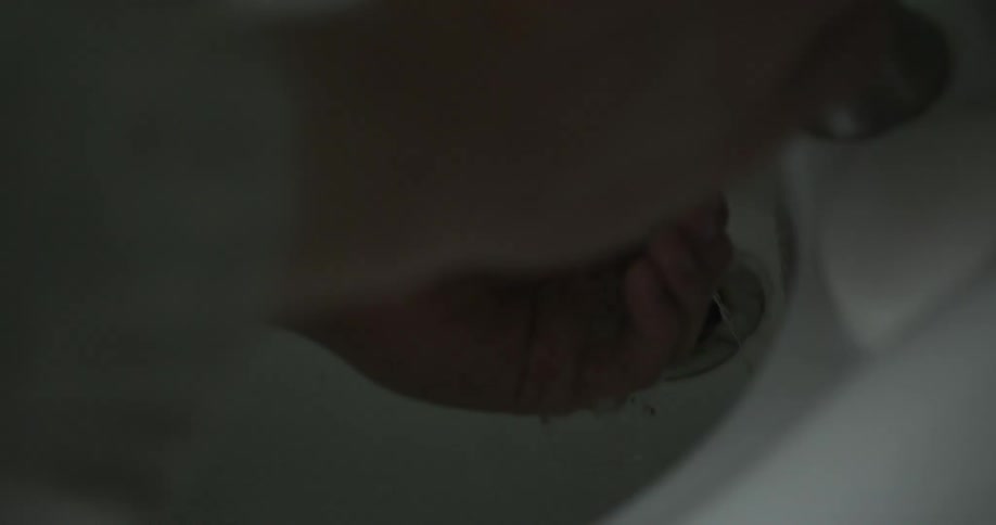 A woman turning on a faucet and washing her hands