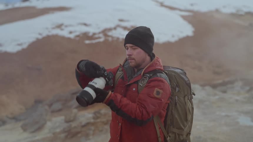 Man with a professional camera using in a natural environment with mountains