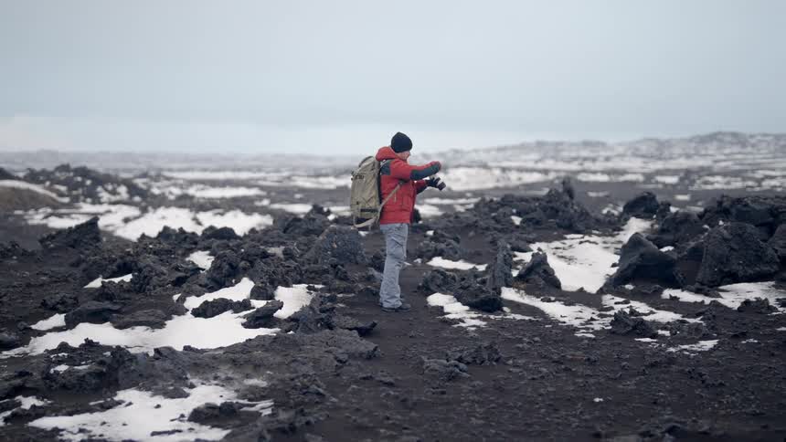 Person taking a picture in a natural environment of rocks with snow