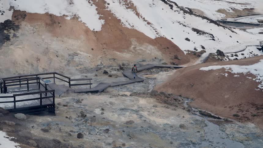 Person walking on a trail in snowy mountains