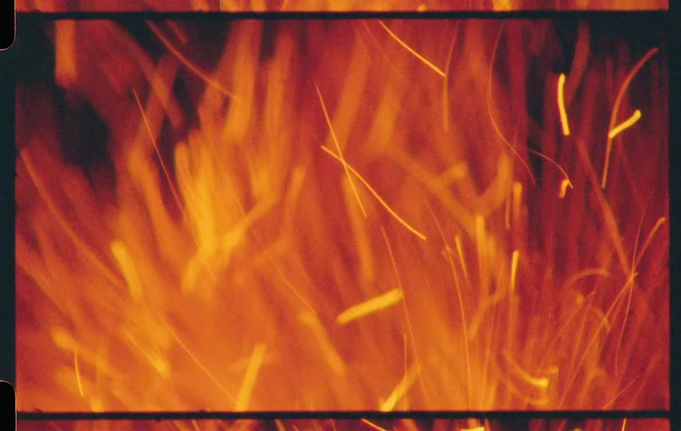 Embers and fire emanating from a campfire at night