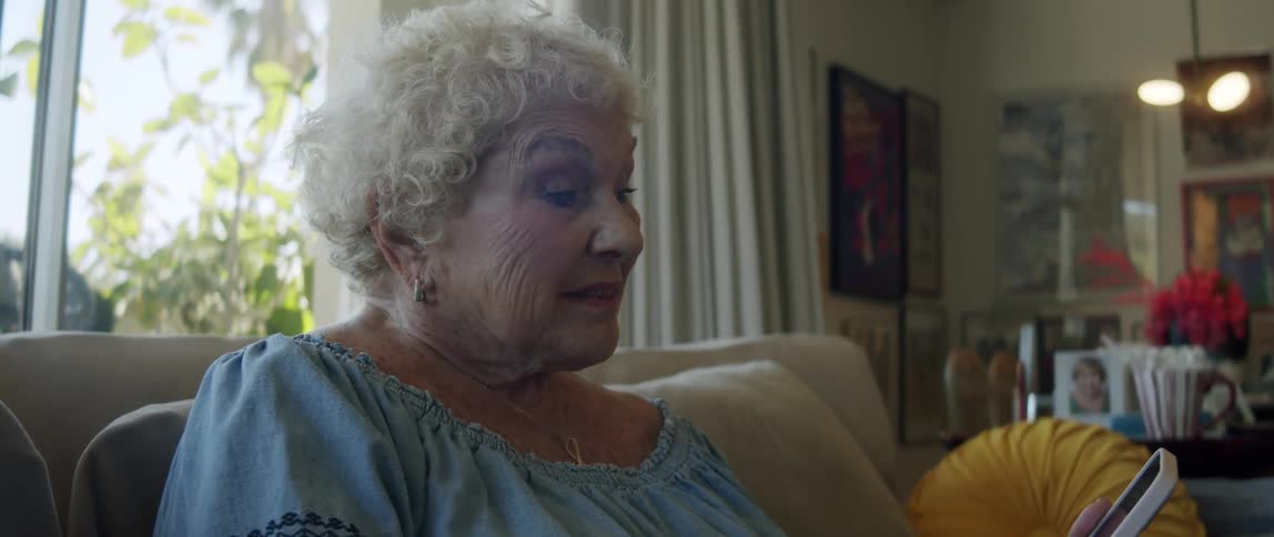 Portrait of an elderly woman sitting and using her iphone