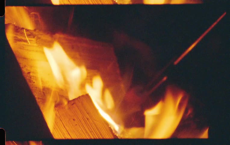 Two marshmallows are roasted over a campfire