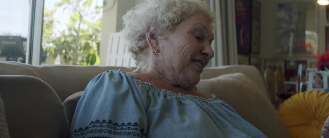 Portrait of a happy elderly woman sitting on the sofa in the living room
