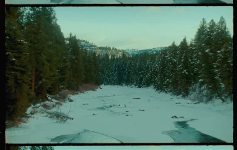 A winding river flows through a snowy forested landscape