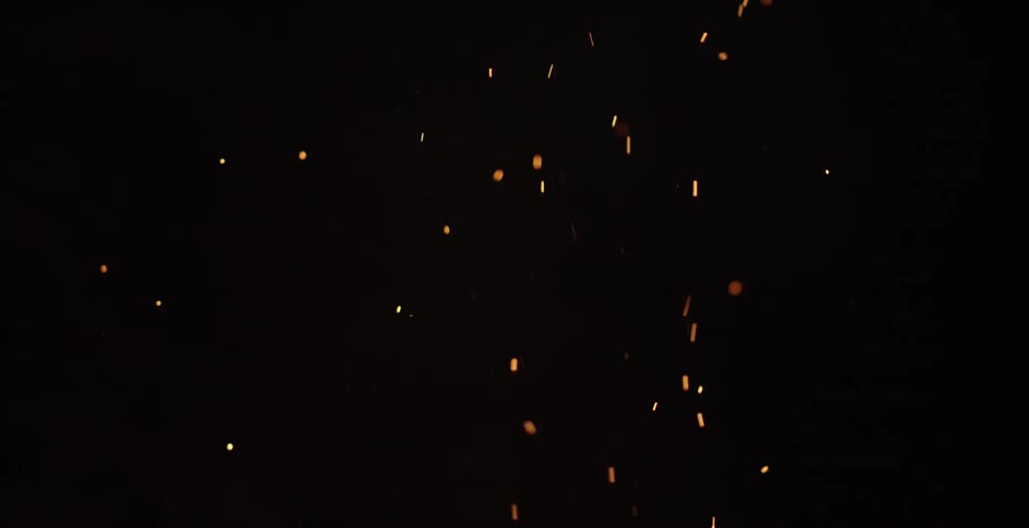 Embers and smoke fly up in the night sky