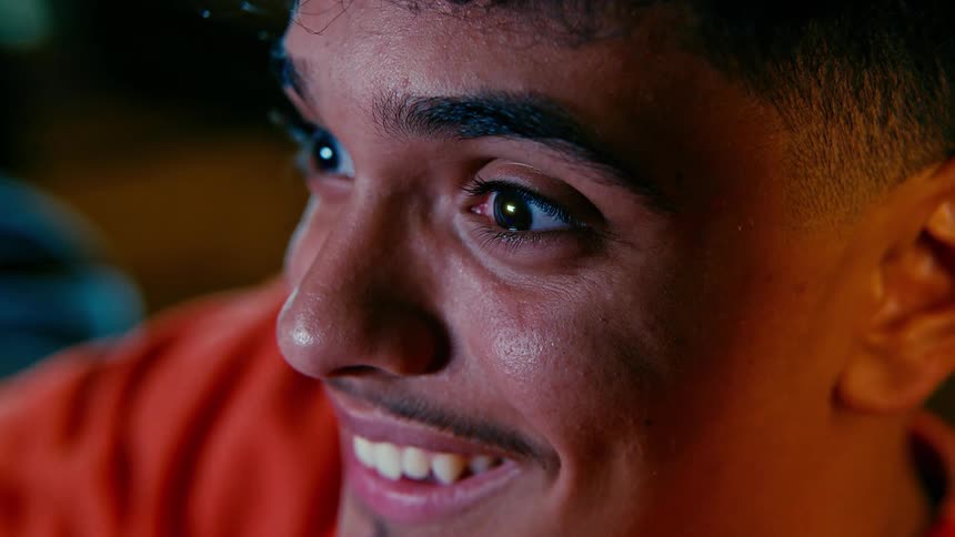 A young mans excited face with wide eyes and a joyful expression capturing an intense moment of focus or thrill