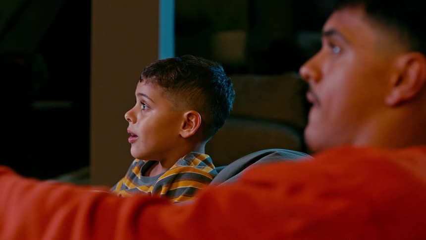 Two friends sitting playing video games