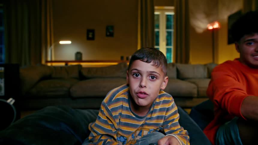 Boy wins while playing a video game against his teenage brother