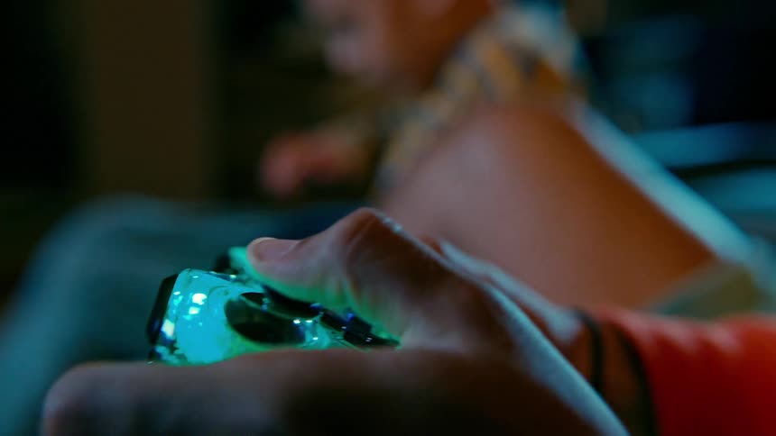 Two brothers play video games together in a house