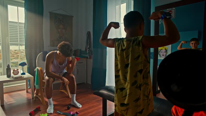 Boy doing double bicep curls and showing his classmate that he is doing light dumbbell exercise