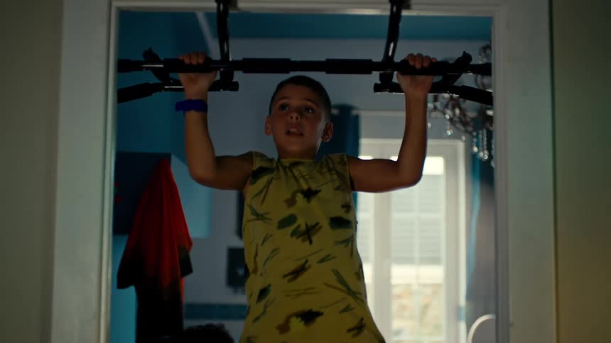 Boy doing pull ups in a doorway