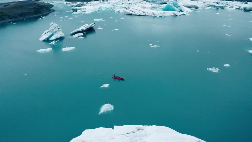 Aerial view of two rowing boats in the middle of the ocean with glaciers