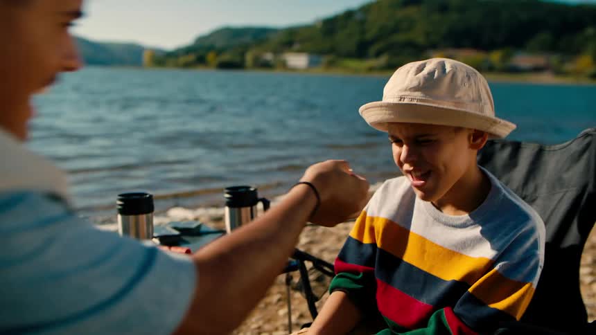 Two boys having fun with a fishing lure by the sea