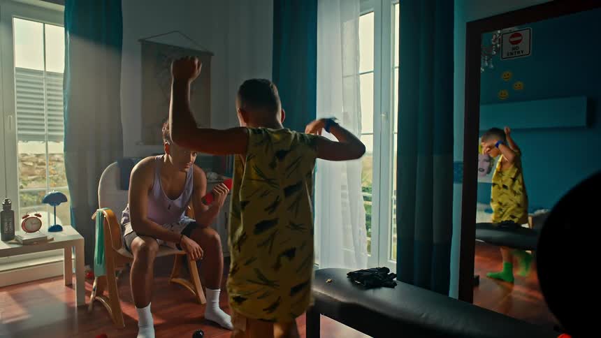 Two brothers are lifting hand weights in their home