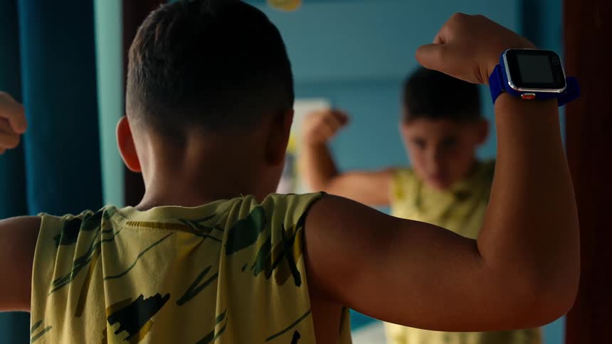 Boy doing double bicep curls in front of the mirror