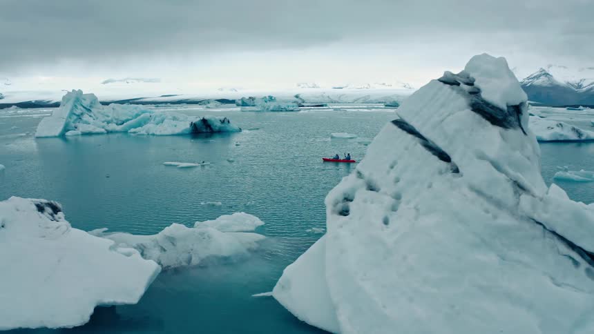 People are rowing past the icebergs
