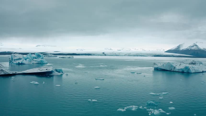 Ice floats in the water of the ocean by the shore