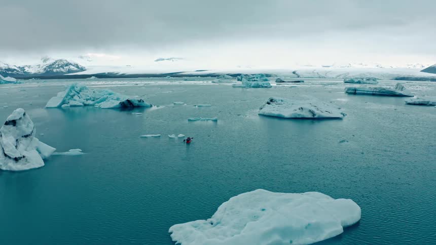 People are kayaking around the icebergs
