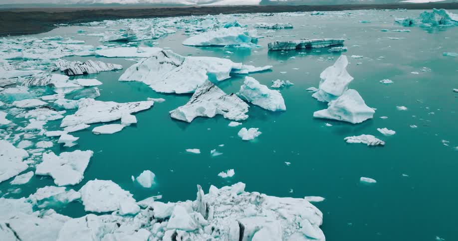 Ice floes in the ocean in front of snowcovered mountains