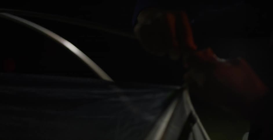 A man and woman set up a tent