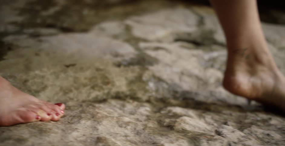 A woman walking on rocky ground