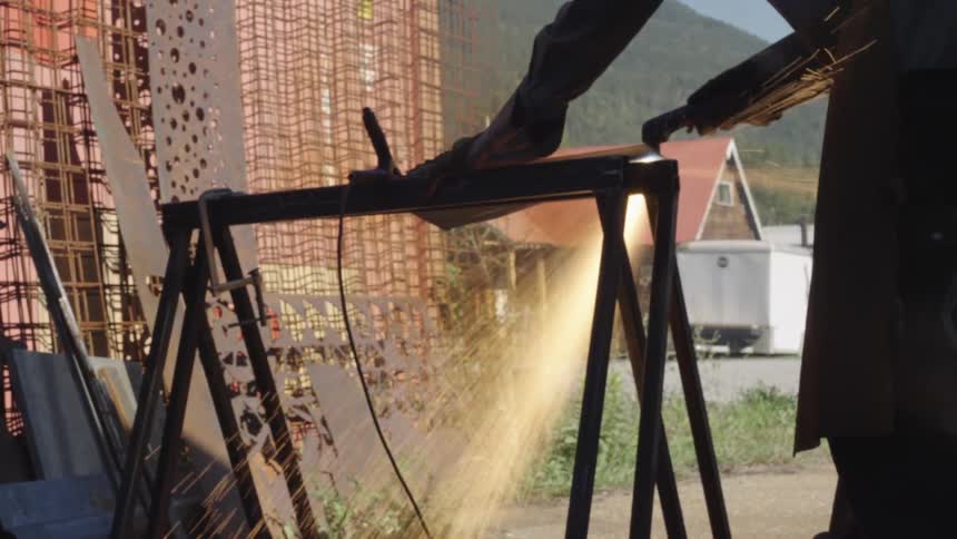 A welder cuts metal with a torch sparks flying in the air