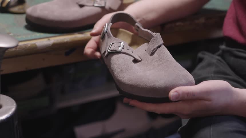 Hand holding a suede leather shoe