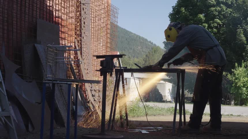 Man in an outdoor area cutting metal