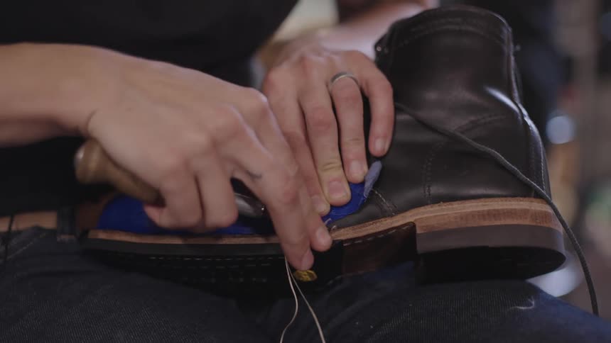 Cobbler threads cord through the base of a shoe
