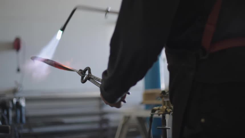 Man heats metal with a blowtorch