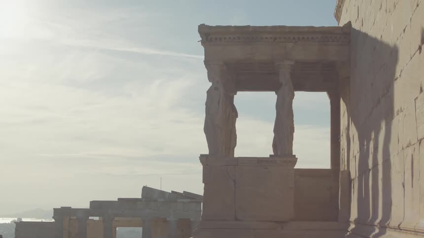 Man walks past stone ruins on a sunny day