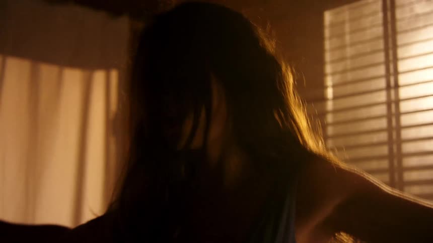 A woman is dancing in the dark room