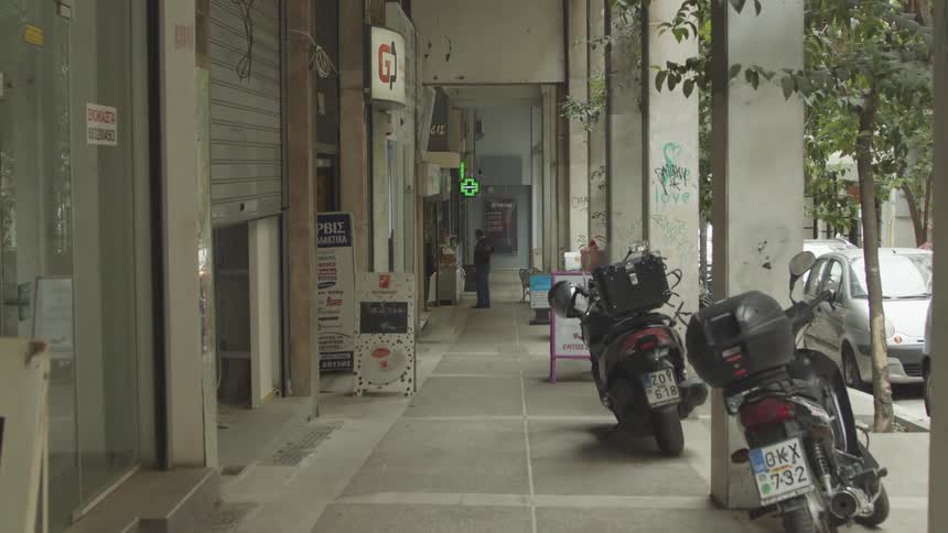 Exterior of shops facing the street with parked motorcycles and cars