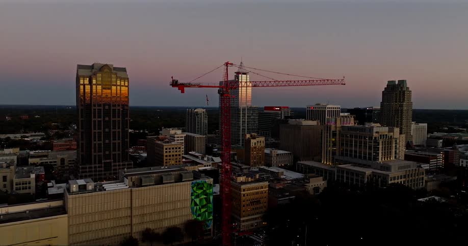 Cityscape with buildings of different heights and a crane in the spotlight