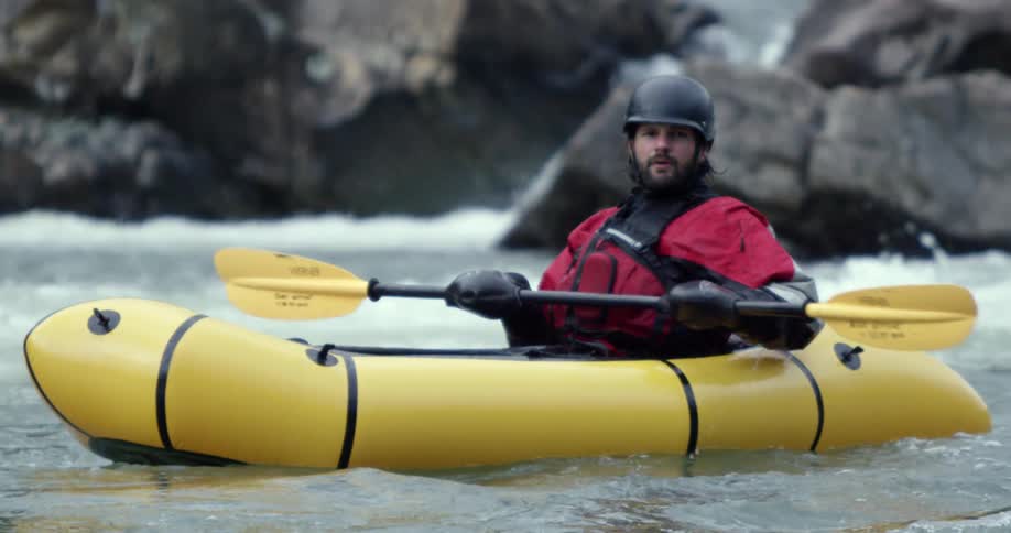 Man floating on a single person raft on the river