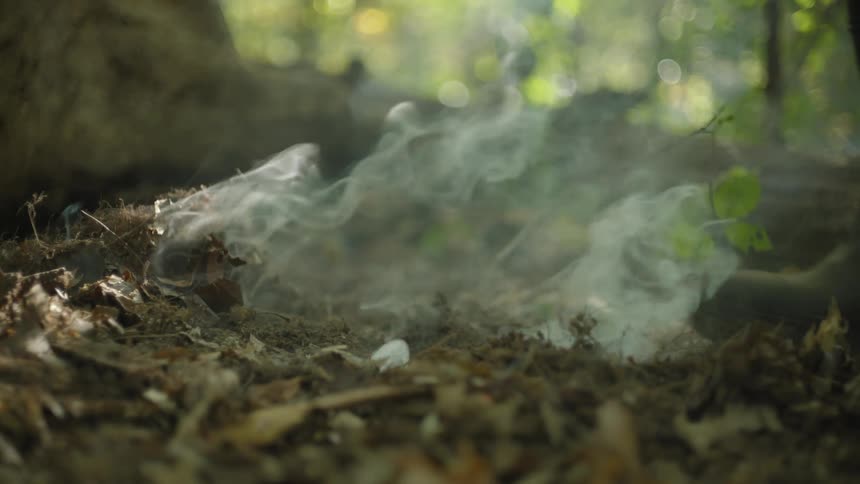 A person extinguishes a small flare on the ground