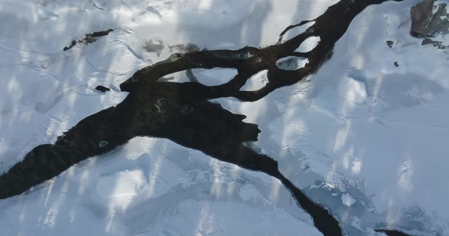 Aerial of a river flowing through a snowcovered mountain range