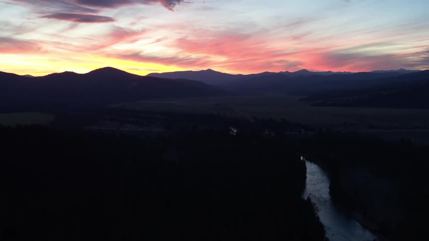 A colorful sunset above a valley with a winding river