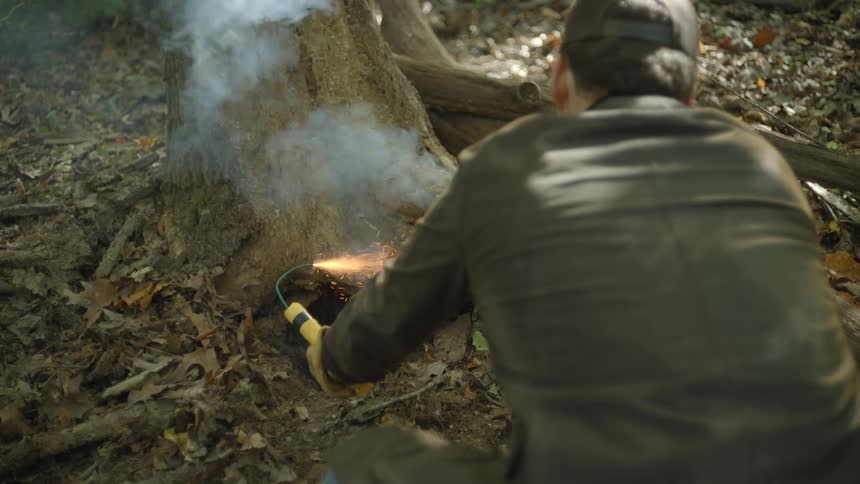 A man lights a stick of dynamite