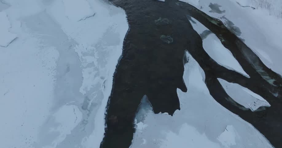 Aerial panorama of a river in a snowy arctic environment
