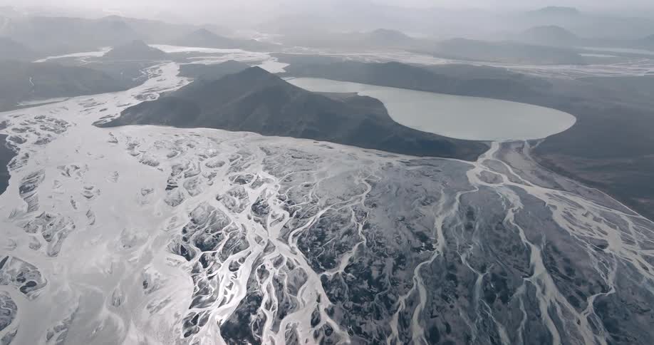 The river a serpentine ribbon of white weaves its way through the desolate landscape