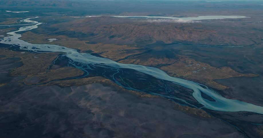 A winding river snakes through a barren volcanic landscape