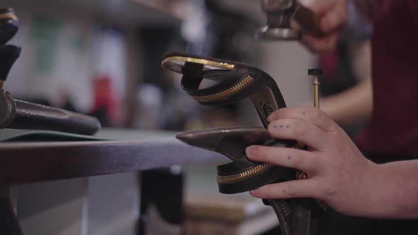 Hands working on the production of a high heel in a factory