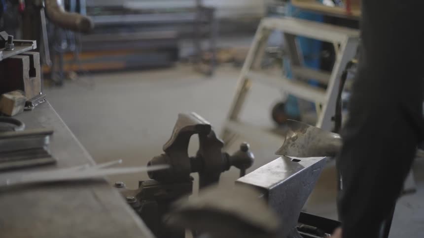 Blacksmith with a hammer shaping a metal on a surface