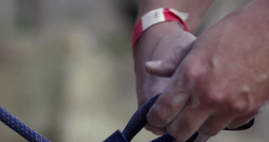 A rock climber secures a rope with a clip
