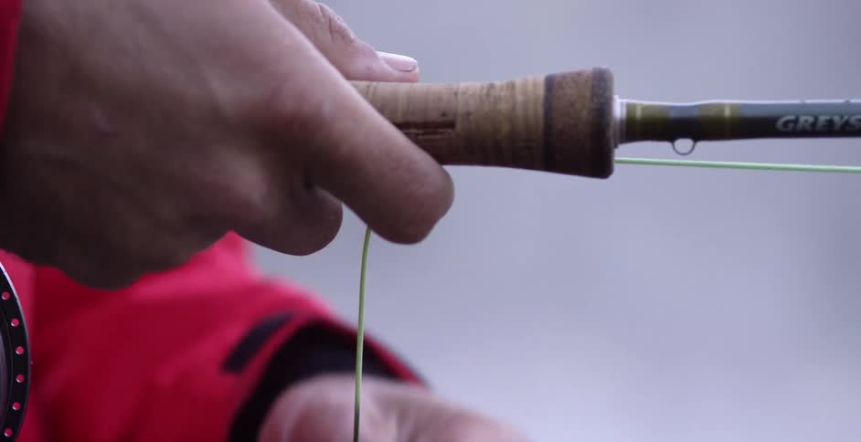 A man running fishing wire on a fishing pole
