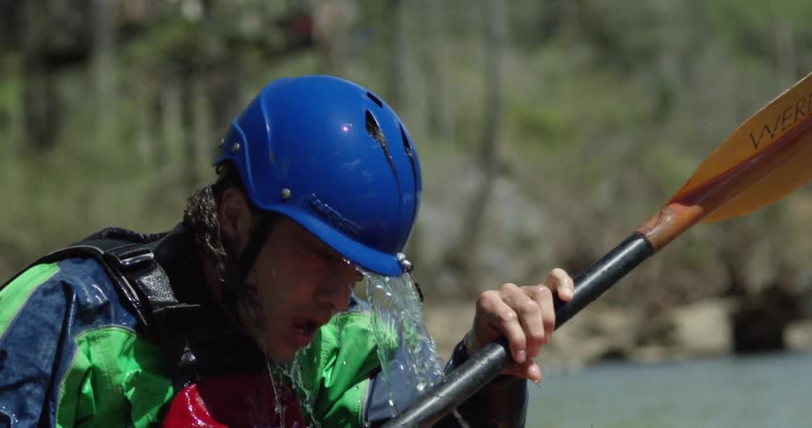 Water pouring from atop a kayakers helmet