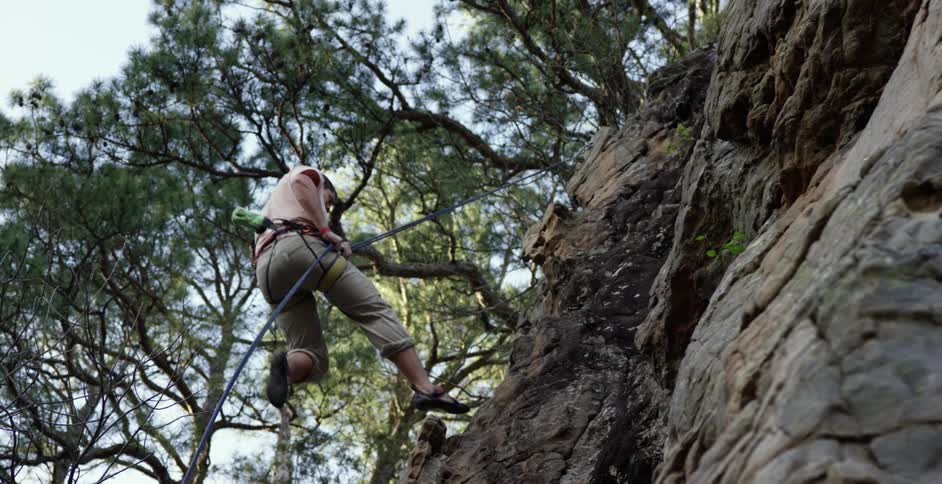 A man is rappelling down a cliff